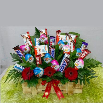 Chocolate flower hamper with assorted candy bars and floral arrangement in a gift crate
