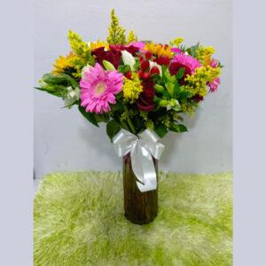 Radiant mixed flower vase arrangement with gerberas, roses, and sunflowers in a glass vase